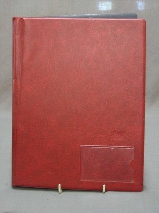 A red album containing a collection of various Commonwealth and other  stamps