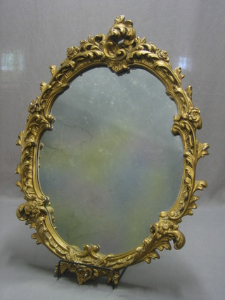 A shaped plate mirror contained in a decorative gilt frame 36"
