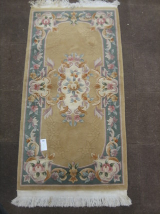 A Chinese yellow ground and floral patterned rug 73" x 36"