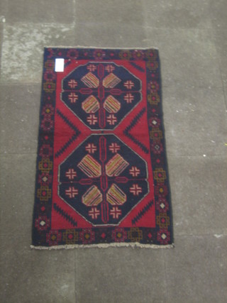 A contemporary red and black ground Belouch rug 54" x 31"
