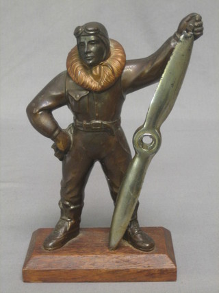 An Art Deco spelter table lighter in the form of an airman with propeller 9", raised on a rectangular oak base (heavily f)