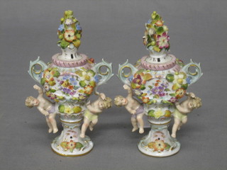 A  pair of Continental miniature porcelain twin handled vases with floral encrusted and cherub decoration 5"