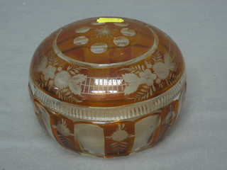 A circular Bohemian amber glass powder bowl and cover with overlay decoration 6" (slight chip to lid)
