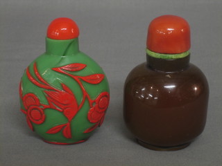An Oriental amber glass snuff bottle 3" together with a green and red glass snuff bottle decorated bird amidst branches 3"