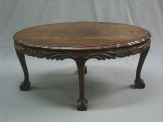 An oval carved mahogany occasional table, raised on cabriole ball and claw supports 36"