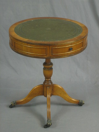 A Georgian style circular yew drum table with green inset surface, fitted 1 drawer raised on tripod supports 20"