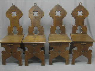 A set of 4 19/20th Century carved Italian walnut hall chairs with shaped backs (some damage)