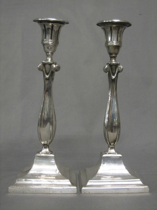 A pair of silver candlesticks with scroll decoration and classical sconces, Sheffield (marks rubbed and 1 f) 12"