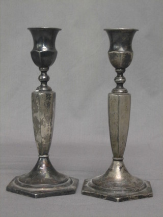 A pair of silver plated candlesticks raised on octagonal bases 8"