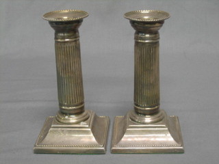 A pair of modern silver reeded candlesticks, raised on square bases 6"