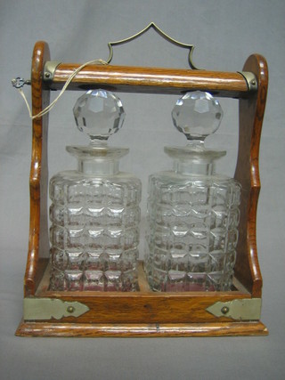 An oak and silver plated tantalus fitted 2 associated spirit decanters