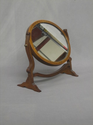 A small oval Georgian style plate dressing table mirror contained in a mahogany swing frame 12"