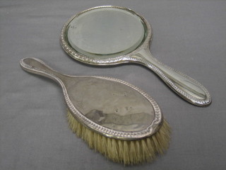 A silver backed hand mirror and hair brush