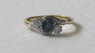 An 18ct gold dress ring set an oval cut sapphire supported by diamonds and  with diamonds to the shoulders