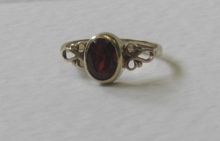 A 9ct gold dress ring set an oval cut red stone
