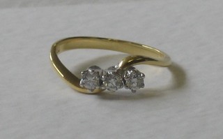 An 18ct yellow gold cross-over dress ring set 3 diamonds, approx 0.25ct