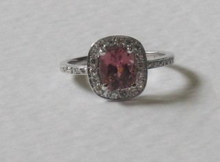 An 18ct white gold dress ring set a pink sapphire surrounded by diamonds, approx 0.50/1ct