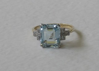An 18ct yellow gold dress ring set a rectangular cut aquamarine surrounded by 6 diamonds