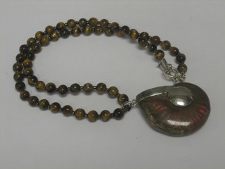 A string of Tigers Eye beads hung an ammonite shaped pendant