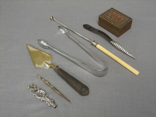 A small wooden stamp box with hinged lid, a silver handled paper knife with tortoiseshell blade, a pair of plated sugar tongs etc