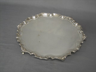 A large circular silver plated salver with bracket border, raised on hoof feet 16"