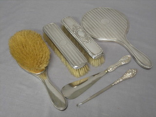 A silver backed 3 piece dressing table set comprising hand mirror, hair brush and clothes brush, together with a silver backed clothes brush, ditto shoe horn and boot hook