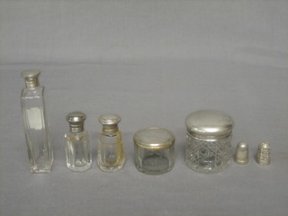 A circular dressing table jar with silver lid, a circular rouge pot, 3 cut glass scent bottles with silver lids and 2 silver thimbles