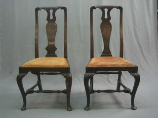A pair of 18th Century Continental Queen Anne style slat back dining chairs with carved slat backs and upholstered drop in seats, raised on cabriole supports united by turned and block stretchers