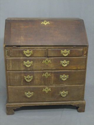 A Georgian Country oak bureau, the fall front revealing a well fitted interior above 2 short and 3 long graduated drawers with brass swan neck drop handles, raised on bracket feet 33"