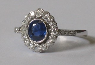 An 18ct white gold dress ring set an oval sapphire supported by diamonds