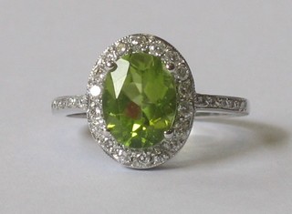 A lady's 18ct white gold dress ring set a Peridot surrounded by diamonds