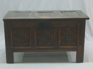 A 17th/18th Century carved oak coffer of panelled construction with hinged lid, the interior fitted a candle box and having an iron lock 41"