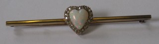 An Edwardian 15ct gold bar brooch set a heart shaped opal surrounded by diamonds