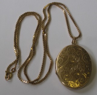 A 9ct gold oval engraved locket hung on a box link chain