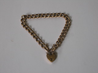A 9ct hollow gold curb link bracelet with heart shaped padlock