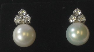 A pair of pearl and diamond drop earrings