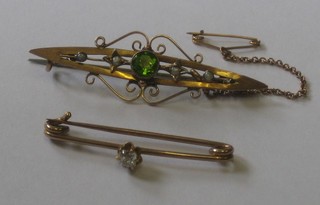 A gold bar brooch set a white stone and 1 other bar brooch set a Peridot and pearls
