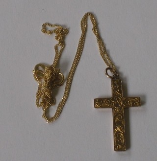 A 9ct gold engraved cross hung on a fine chain