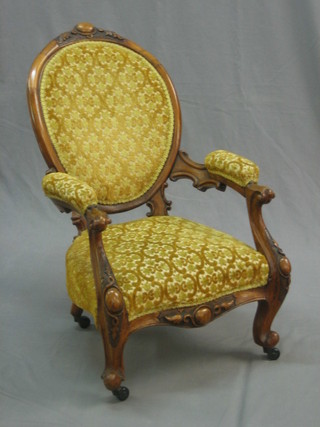 A childs Victorian carved walnut open arm chair raised on cabriole supports