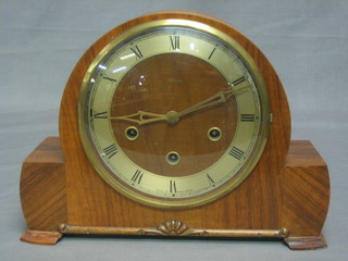 A 1950's chiming mantel clock with silvered dial and Roman numerals contained in an arch shaped walnut case