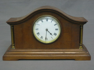 A bedroom timepiece with enamelled dial and Roman numerals contained in an arch shaped mahogany case