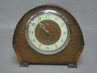 A 1950's 8 day mantel clock with Arabic numerals contained in an arch shaped oak case