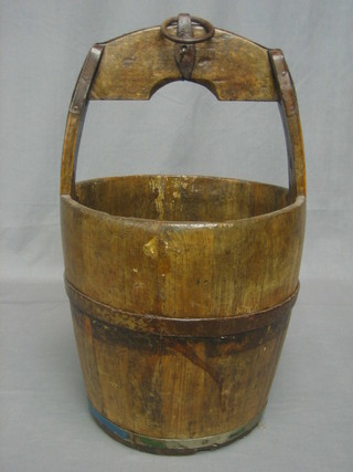A circular reproduction wooden well bucket