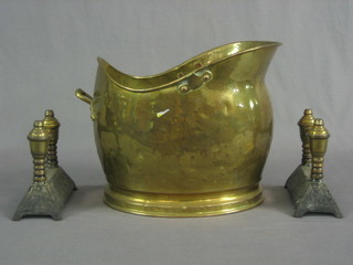 A brass helmet shaped coal scuttle and a pair of brass and iron fire dogs