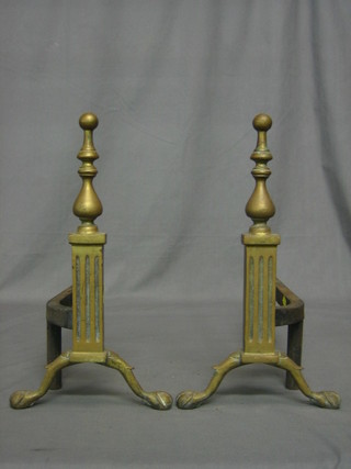 A pair of iron and brass fire dogs