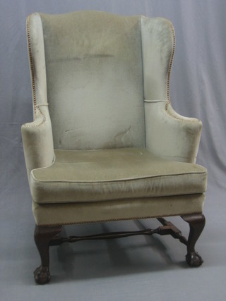 A Georgian style mahogany framed winged armchair upholstered in green material