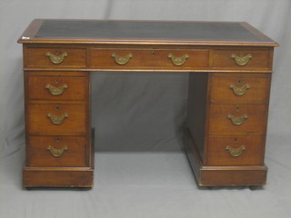 A mahogany kneehole pedestal desk with inset tooled writing surface, fitted 1 long drawer above 8 short drawers 47"