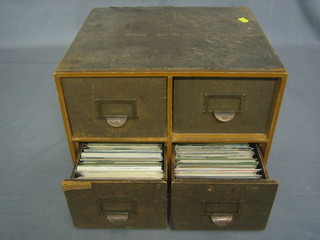 A table top 4 drawer card index containing various postcards