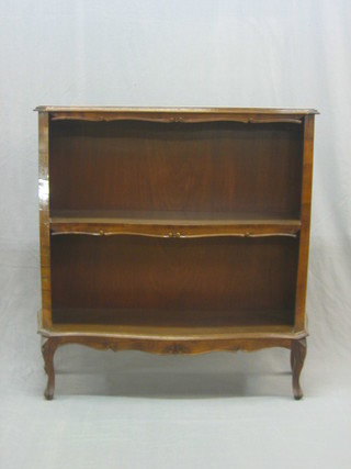 A Continental style shaped mahogany 2 tier bookcase, having a cross banded top and raised on cabriole supports 39"