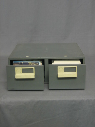 A metal table top 2 drawer filing cabinet containing various postcards